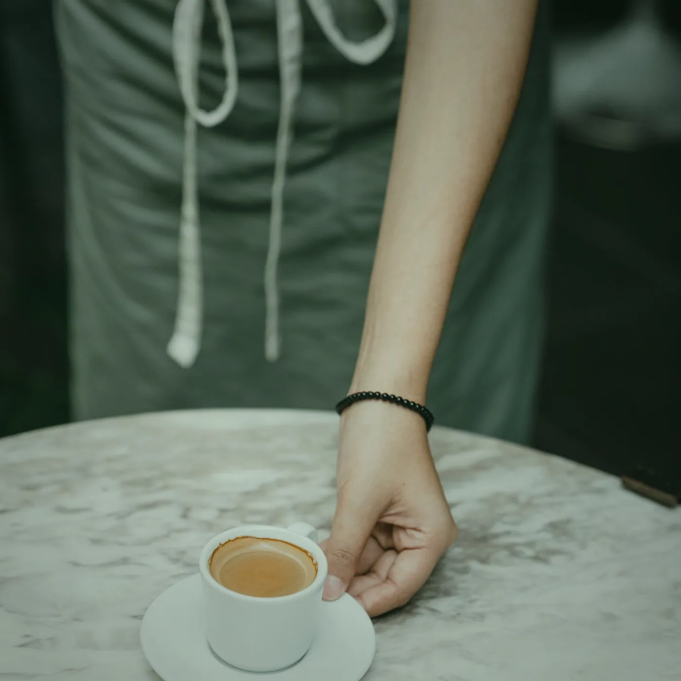 Tea served between hands on the side table.